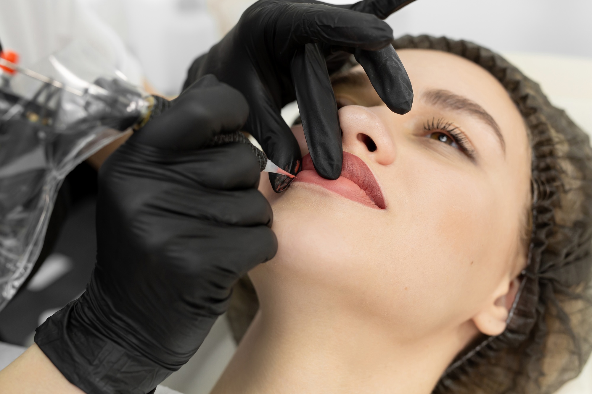 Close-up of the permanent makeup procedure. Lip makeup in the cosmetologist's salon